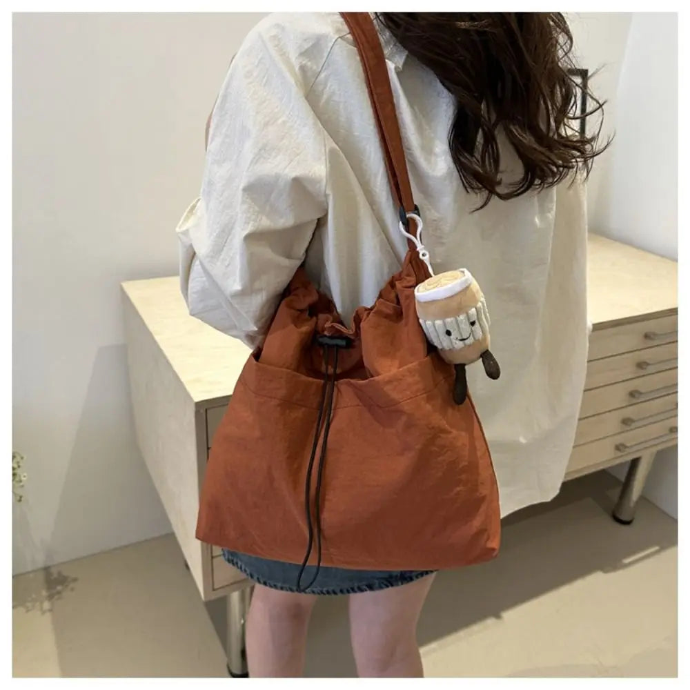 Cartera balde de nylon con cordón y dije opcional