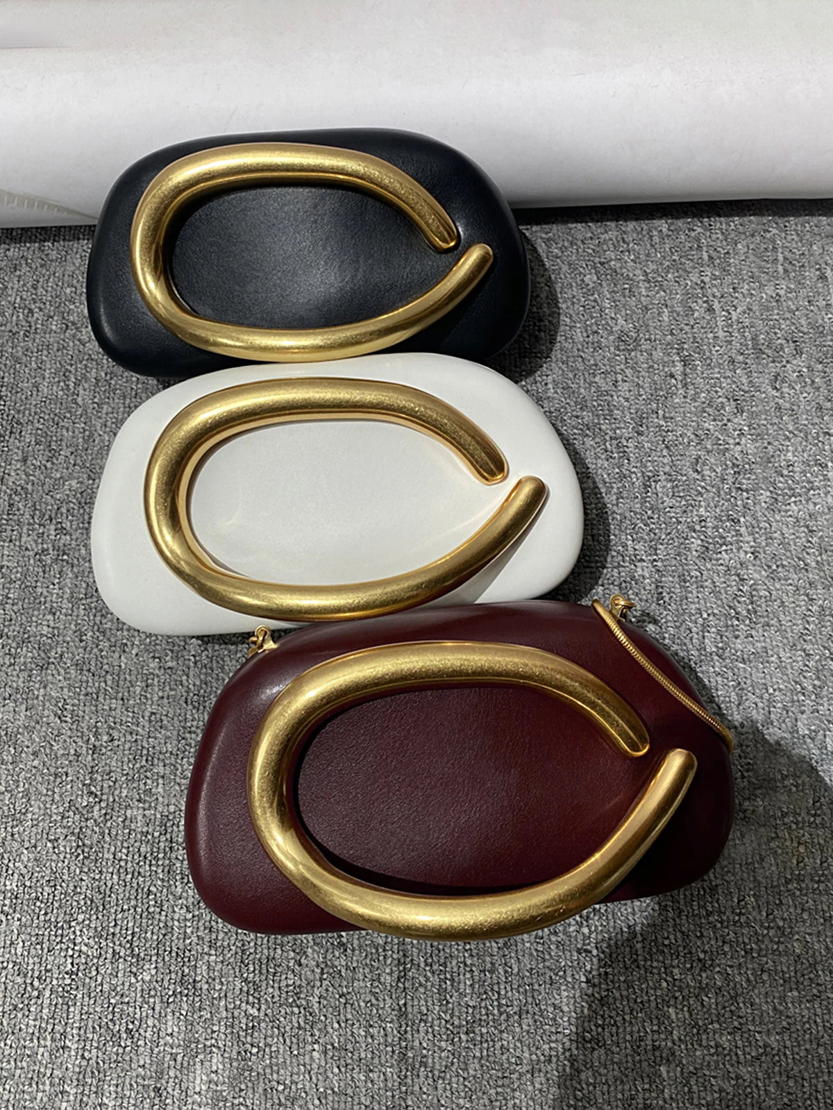 Clutch ovalado de fiesta con cadena y cierre metálico