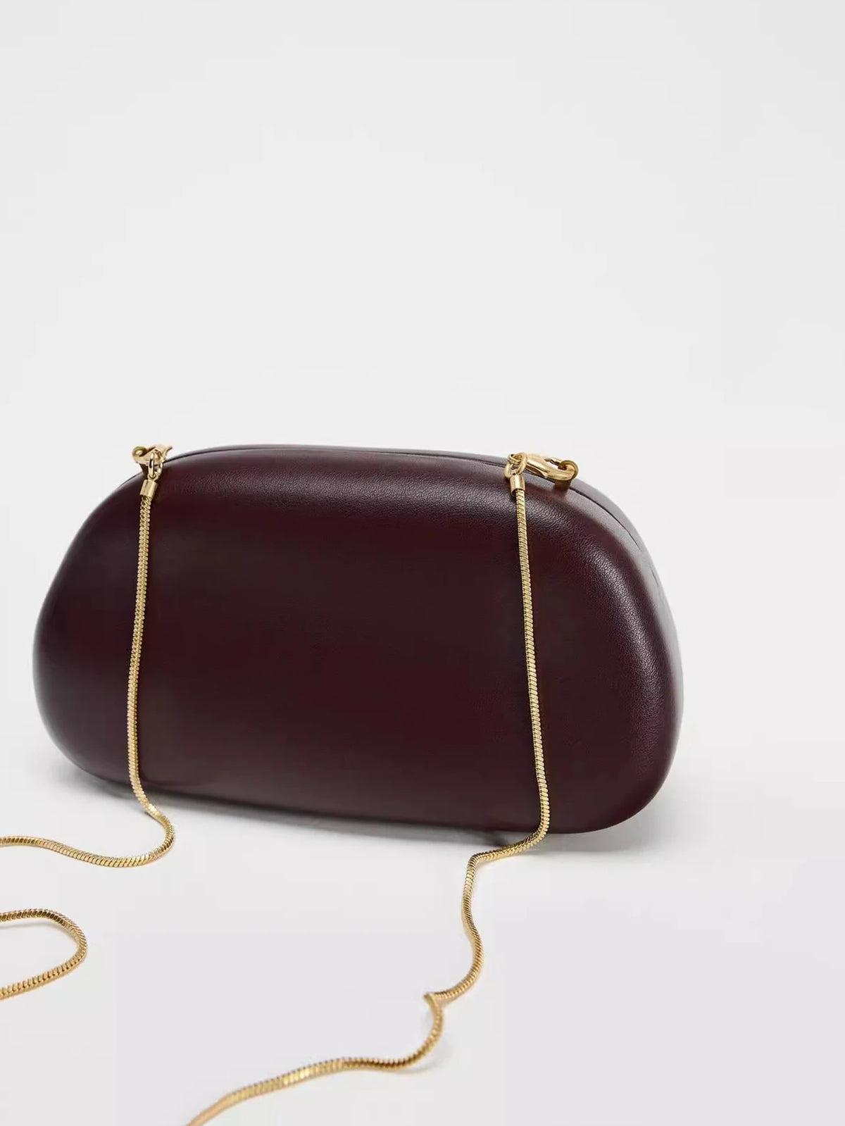 Clutch ovalado de fiesta con cadena y cierre metálico