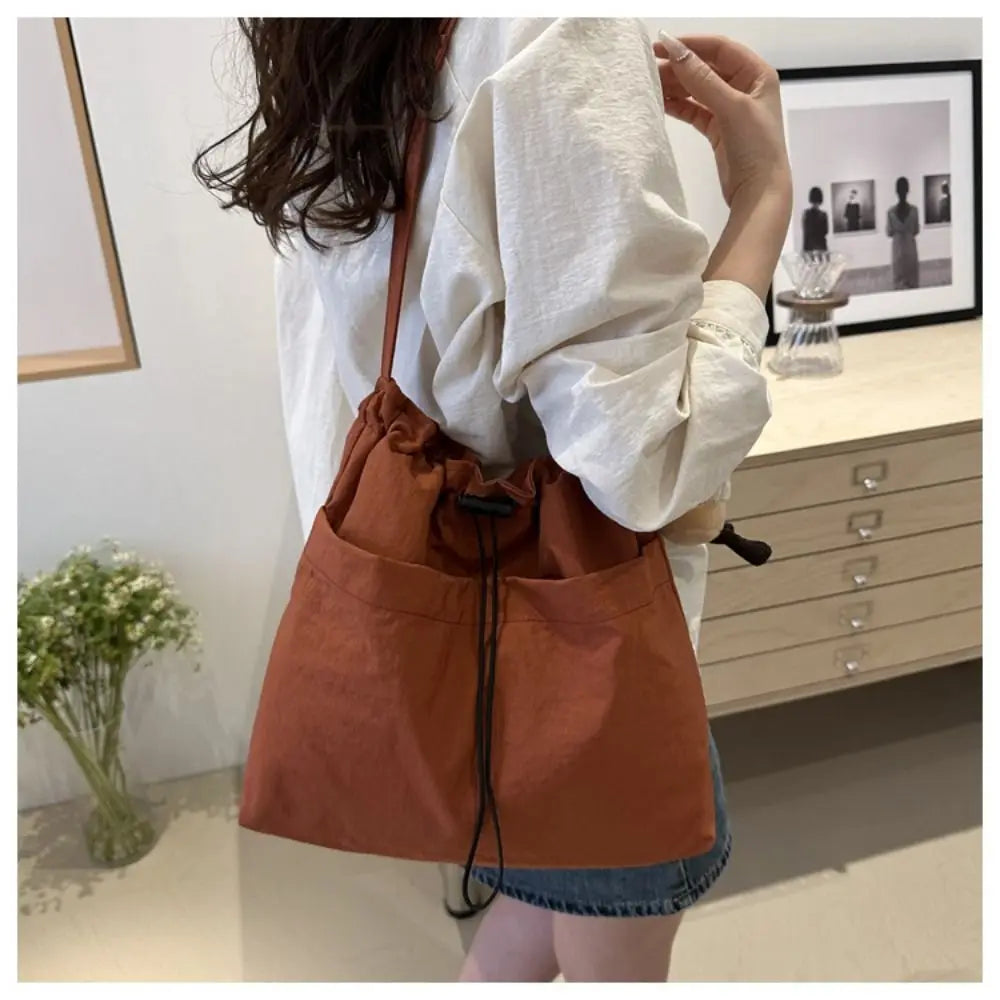 Cartera balde de nylon con cordón y dije opcional