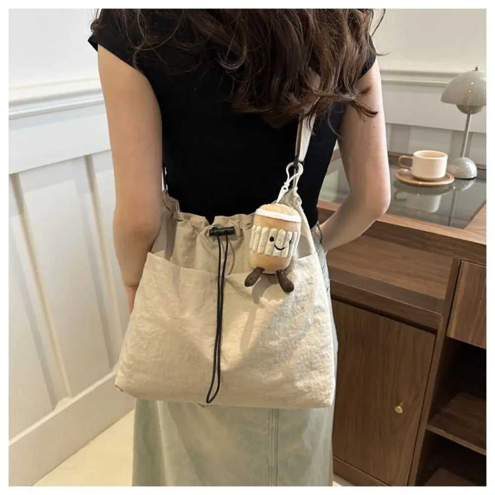 Cartera balde de nylon con cordón y dije opcional